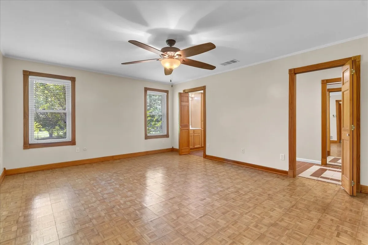 Primary bedroom with ceiling fan and ensuite bathroom.