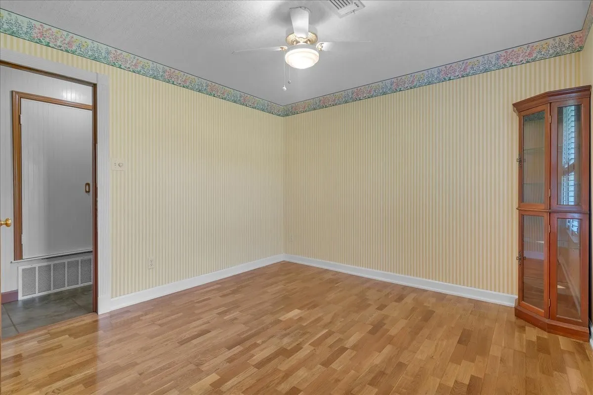 Guest bedroom 2 with ceiling fan and decorative ceiling.