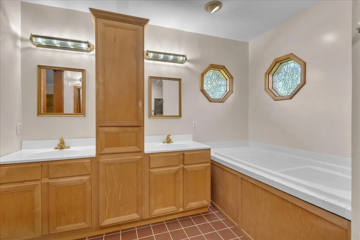 Primary bathroom with dual sinks and jetted tub. Notice the cute windows!