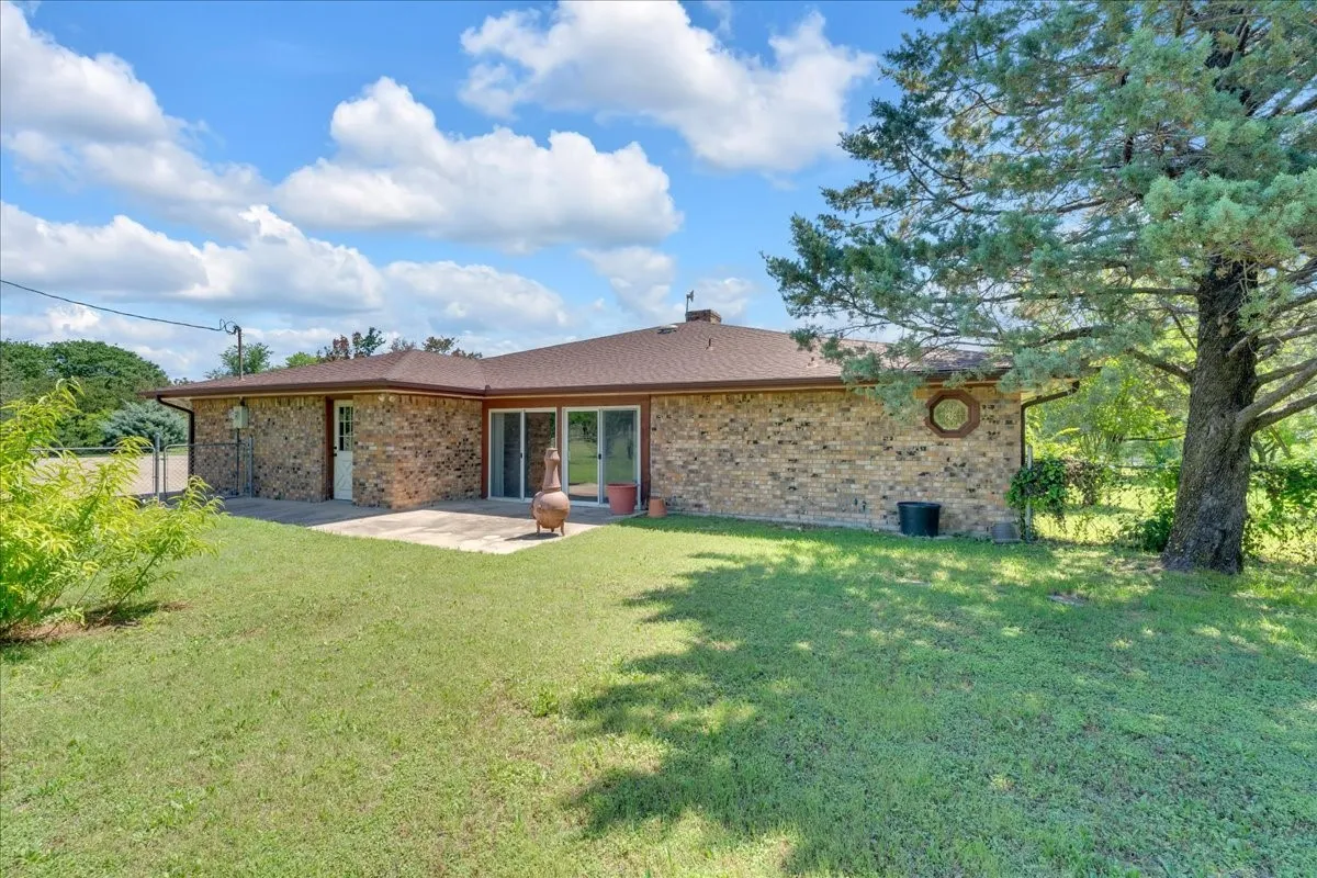View of the back of the house featuring large patio and sliding glass doors.