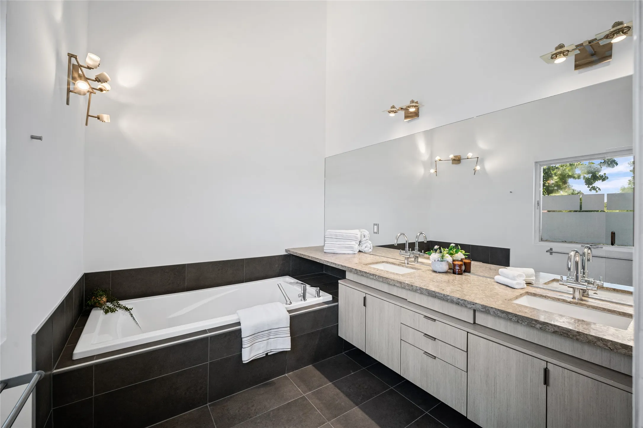 Contemporary bathroom featuring a built-in soaking tub and dual vanity