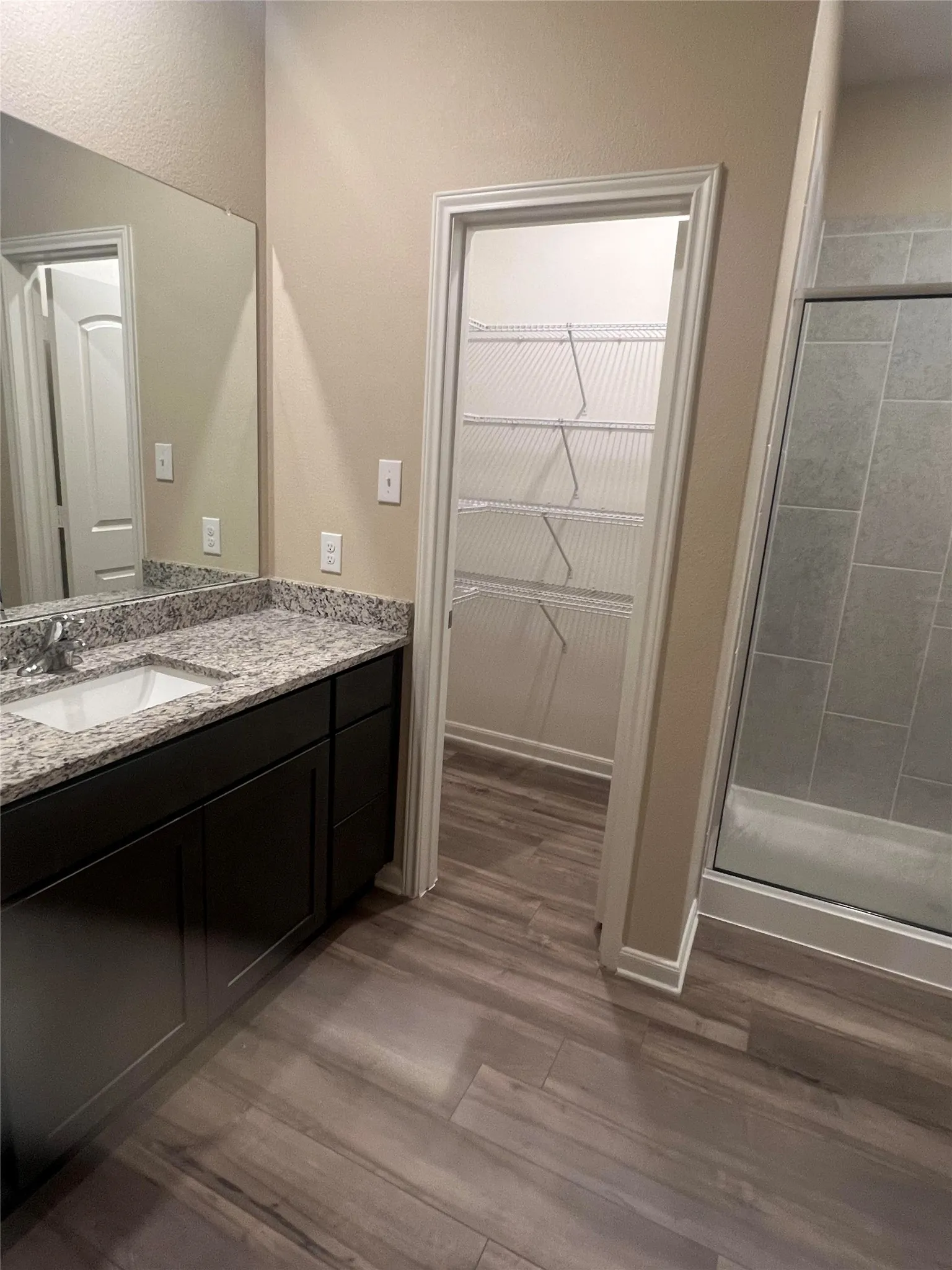 Bathroom featuring a dark wood-finish vanity with a granite countertop and undermount sink