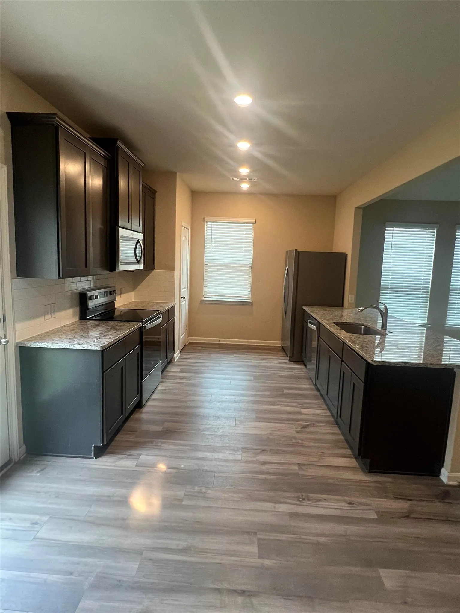 Modern kitchen with dark wood-finish cabinetry and granite countertops