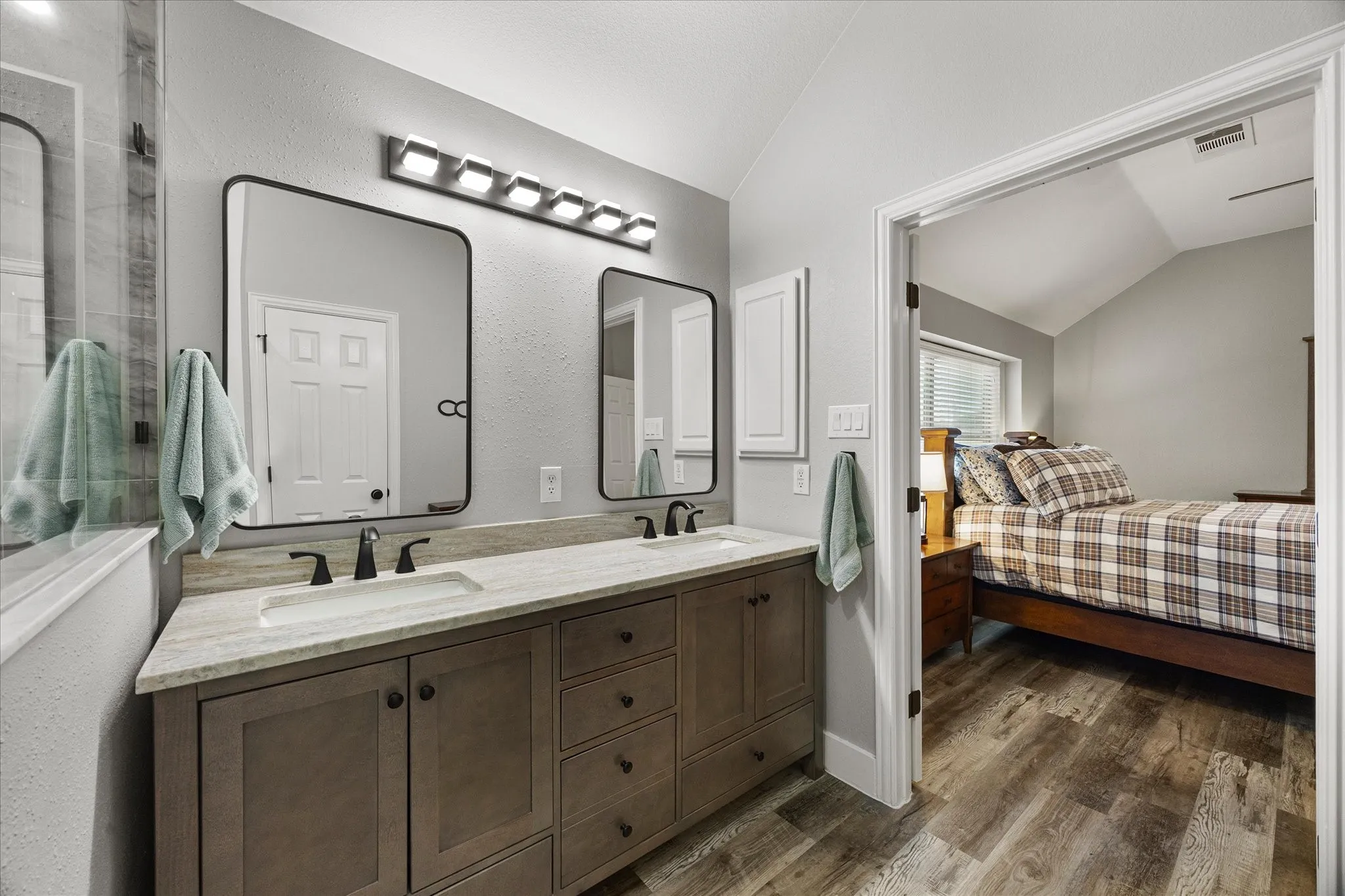 The primary bathroom has been updated with a granite topped vanity with dual sinks, mirrors and lighting.