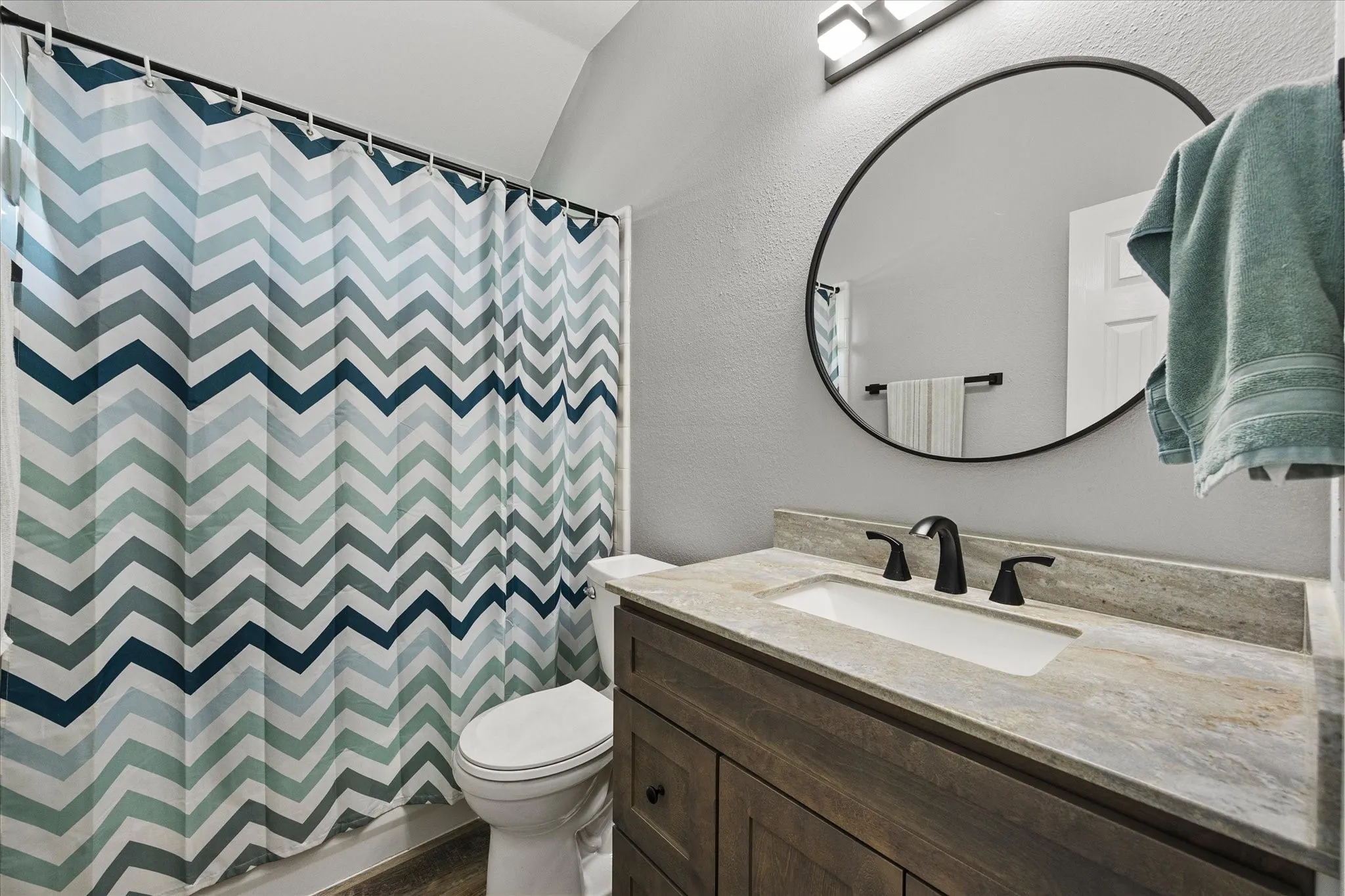 The hall bath has been updated with a granite-topped vanity, mirror, lighting, fixtures and hardware.