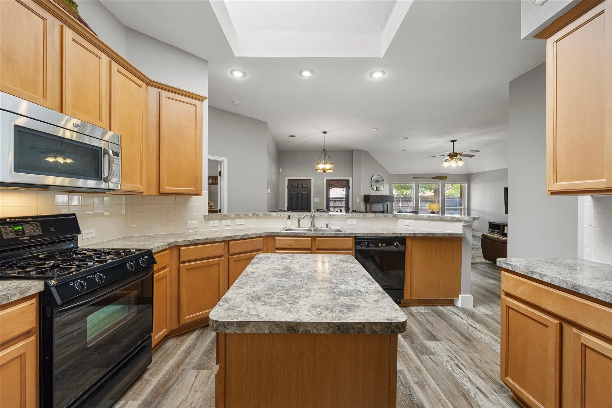. The light and bright kitchen is the heart of the home, with granite-look counters, breakfast bar, prep island and gas range.