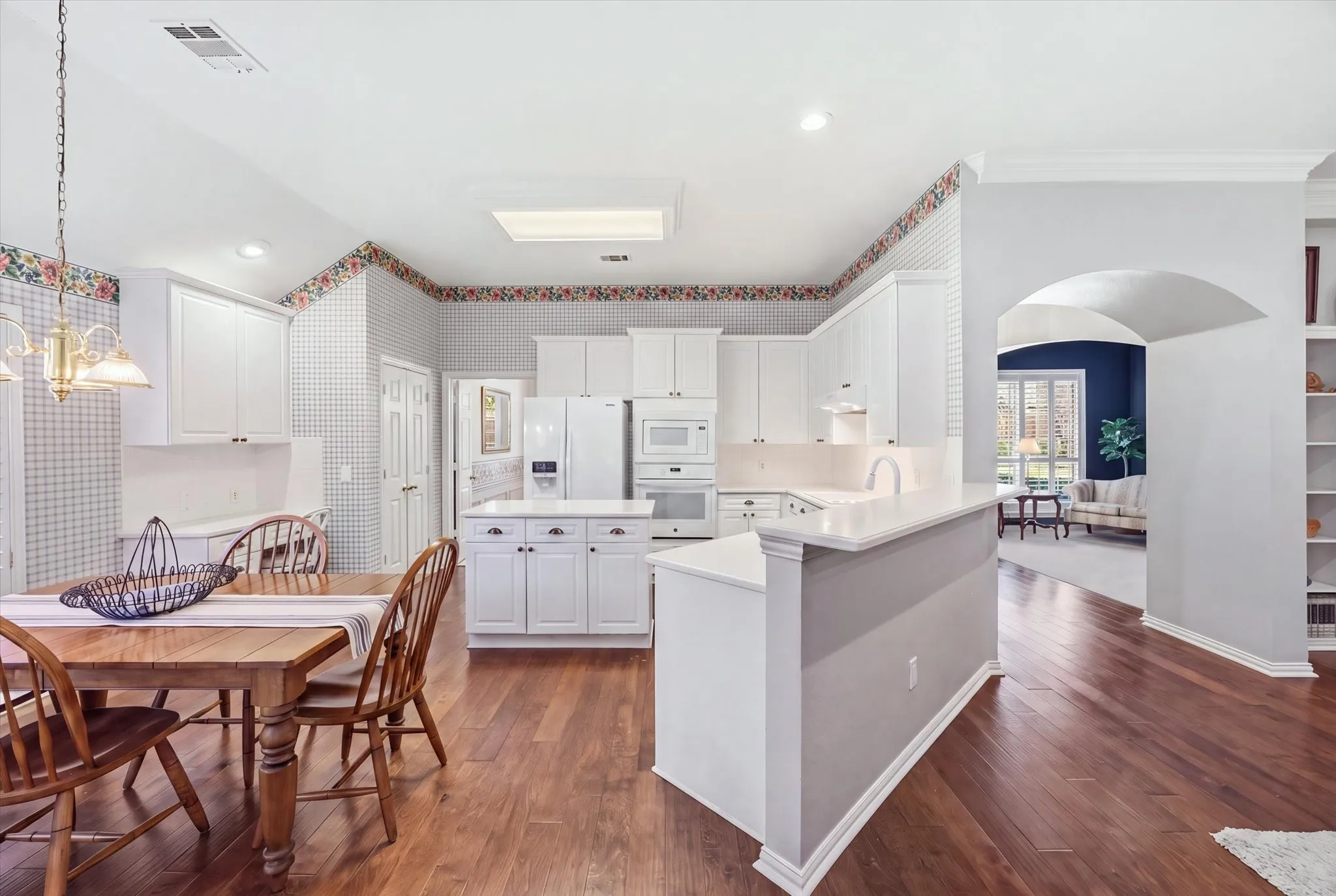 The light and bright kitchen features Corian counter tops and an abundance of cabinetry.