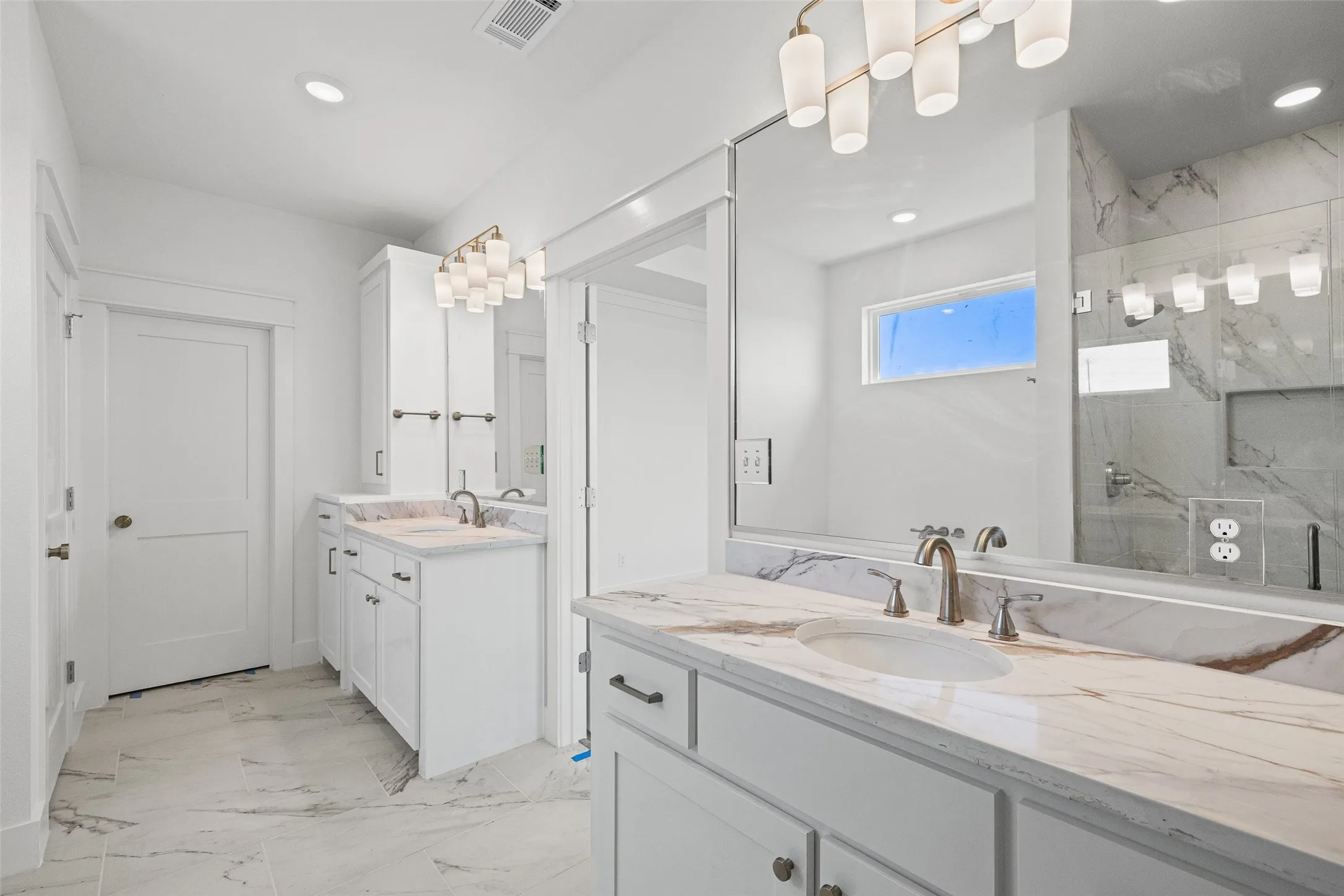 Dual vanity with white cabinetry and integrated sinks, complemented by light-toned, veined countertops
