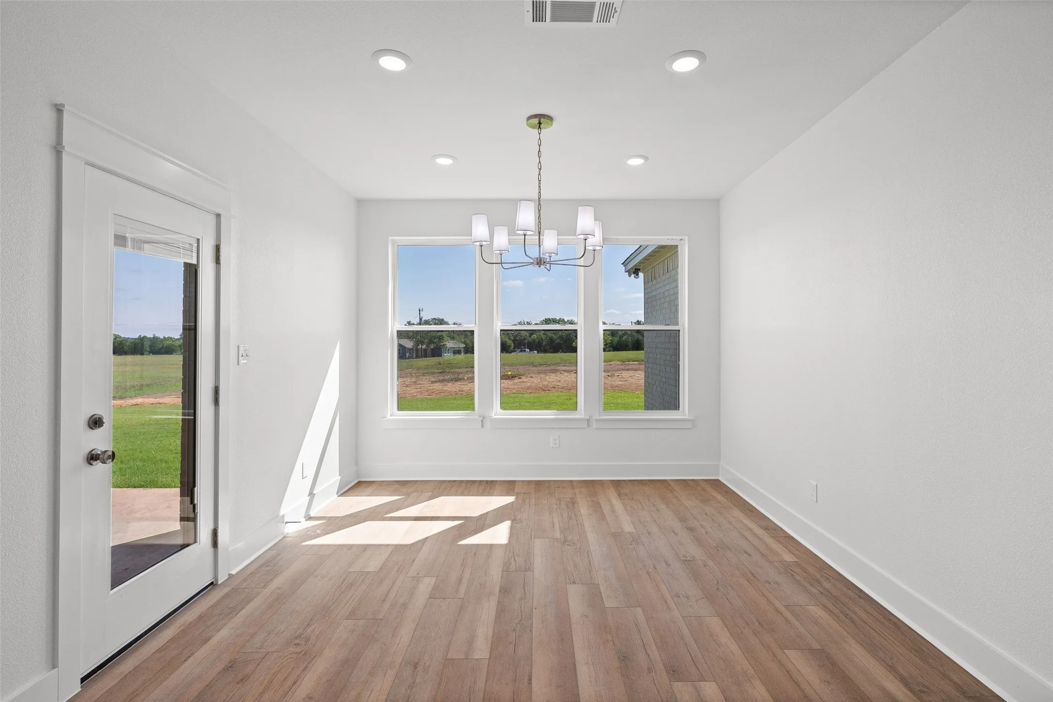 Interior space featuring wood-finish flooring, white walls, and recessed lighting