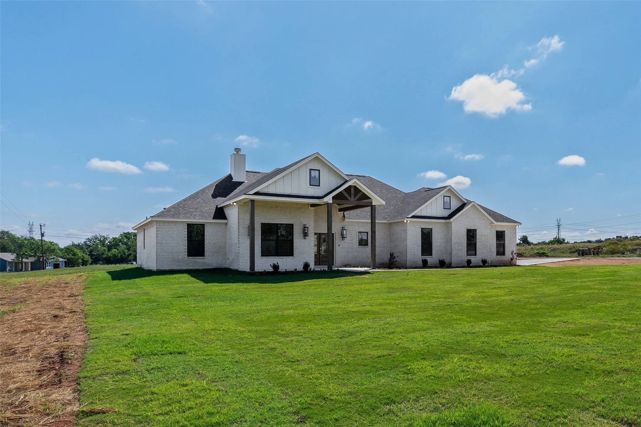 Modern farmhouse exterior featuring white brick and vertical siding accents