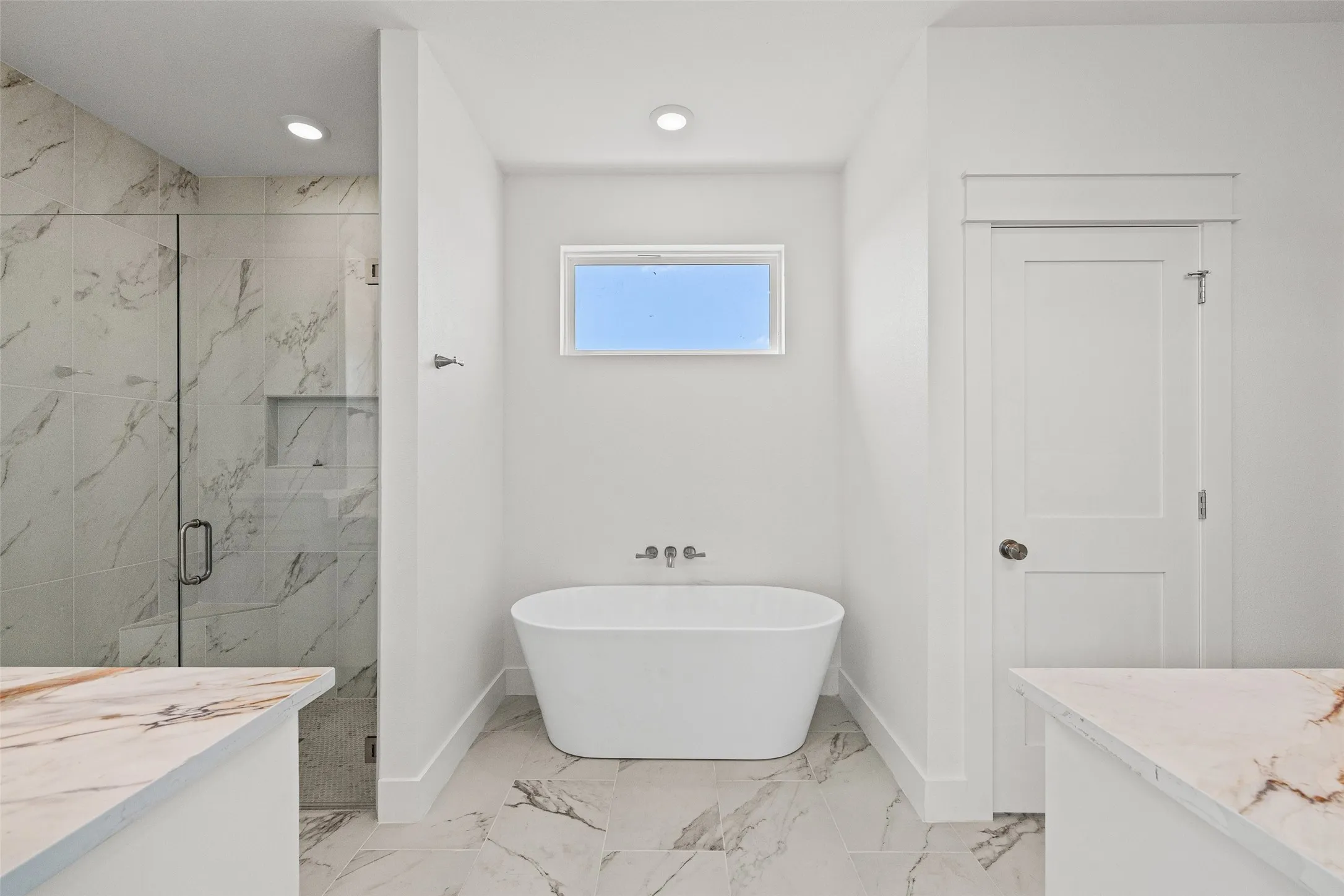 Freestanding soaking tub with wall-mounted fixtures