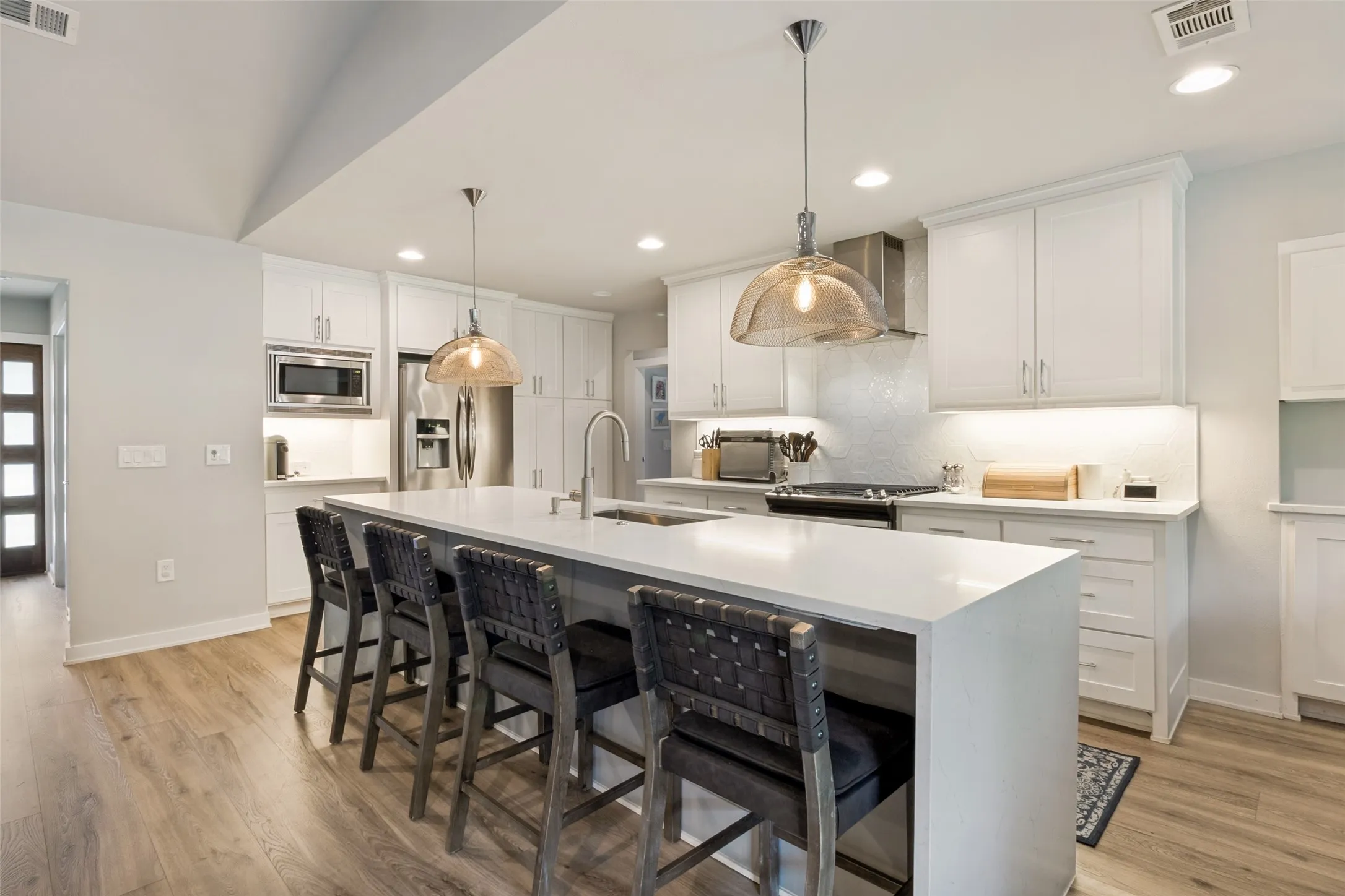 Fully renovated chef’s kitchen blends timeless design and functionality with custom cabinetry, designer lighting, and expansive prep space.