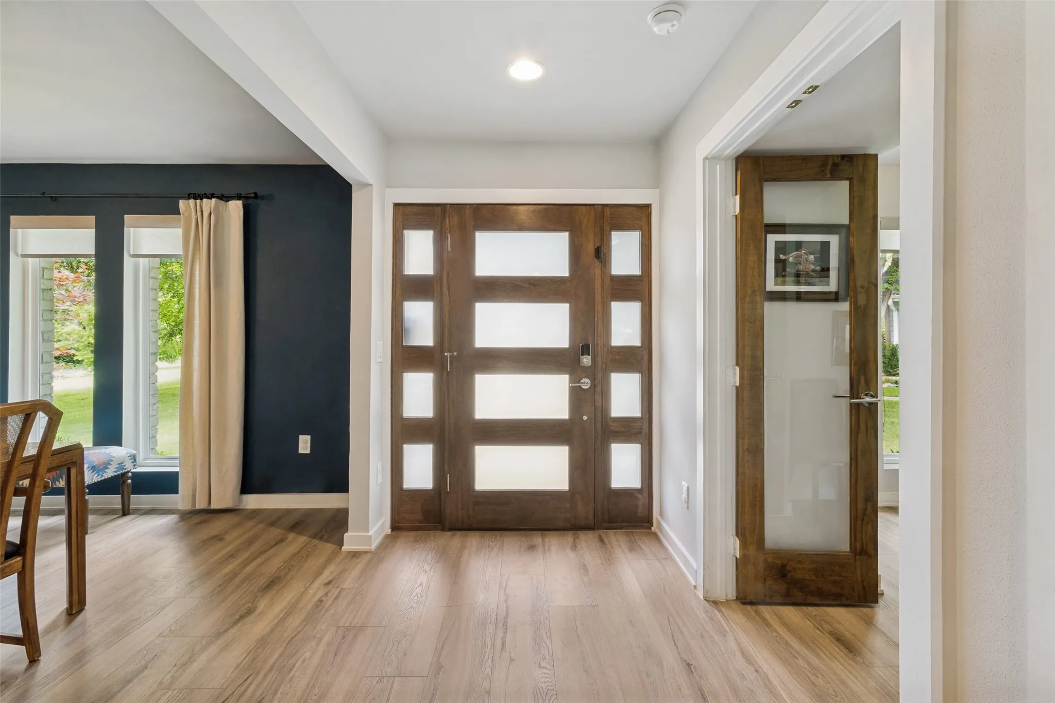 Light-filled entry showcases the high-end LVP flooring and seamless sightlines into the main living spaces.