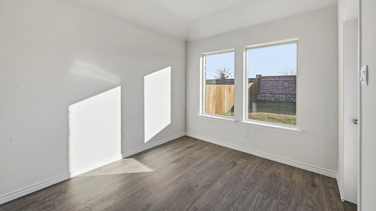 Bright interior room featuring wood-finish flooring, white walls, and two large windows