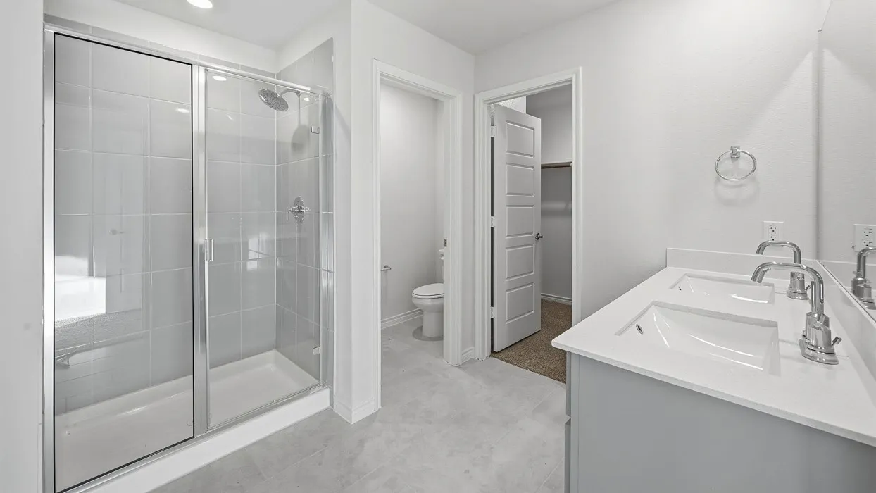 Bathroom with a glass-enclosed shower featuring light grey tile and a built-in bench