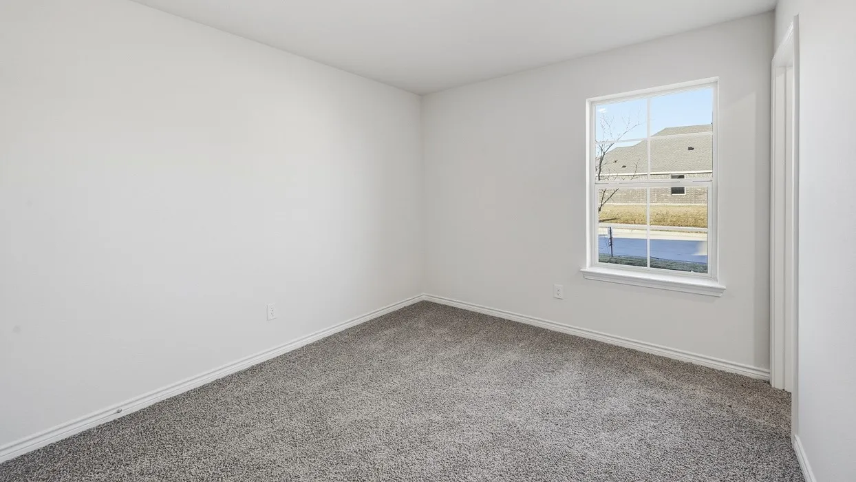 Room featuring a window with white trim, light gray wall-to-wall carpeting, and white baseboards