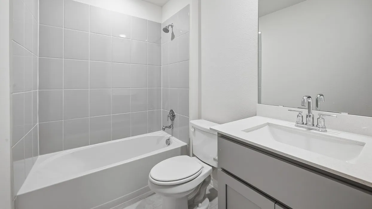 Full bathroom featuring a single vanity with an integrated sink, polished chrome faucet, and a large wall-mounted mirror