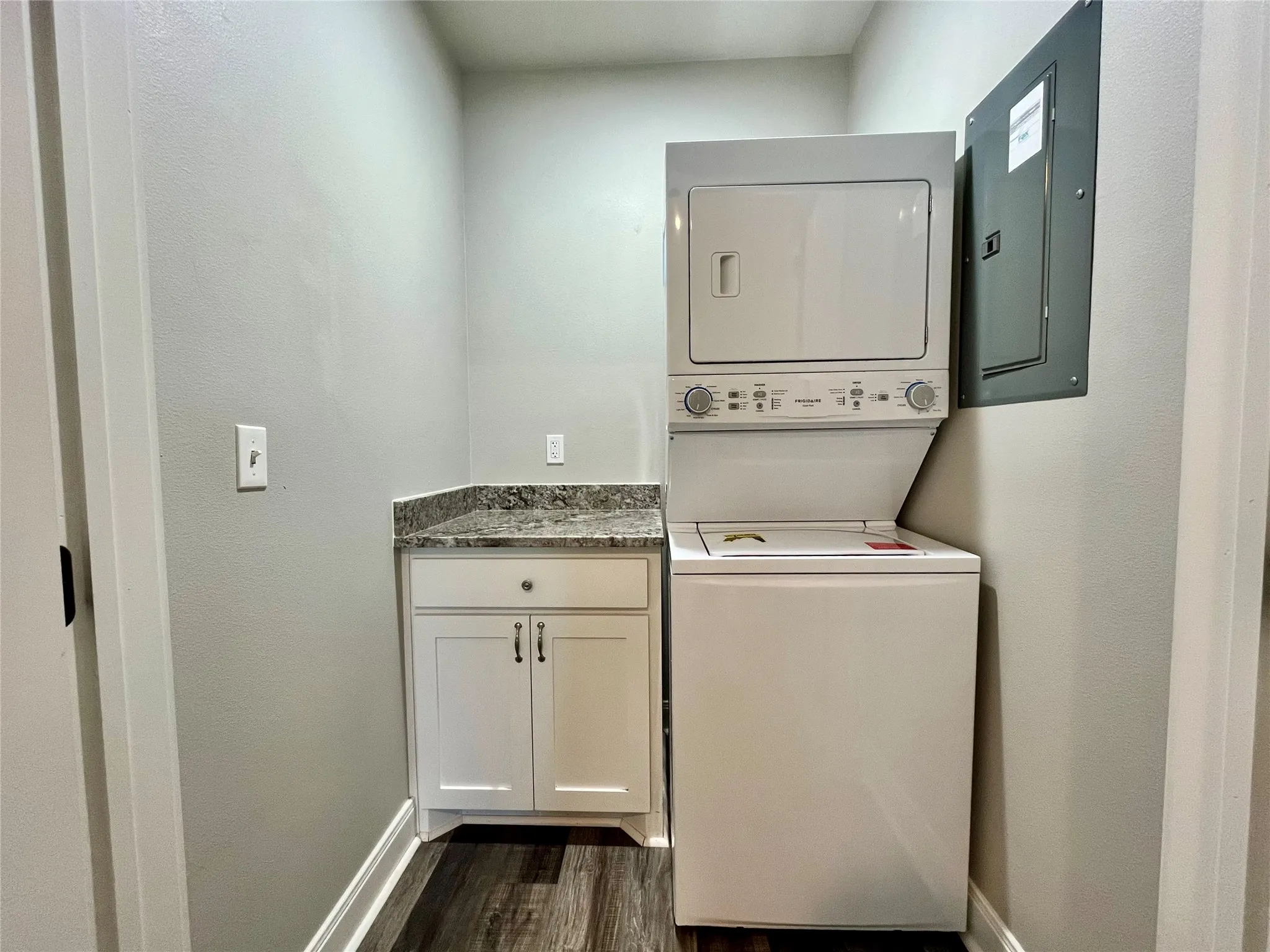 Convenient dedicated laundry space complete with a stacked washer and dryer.