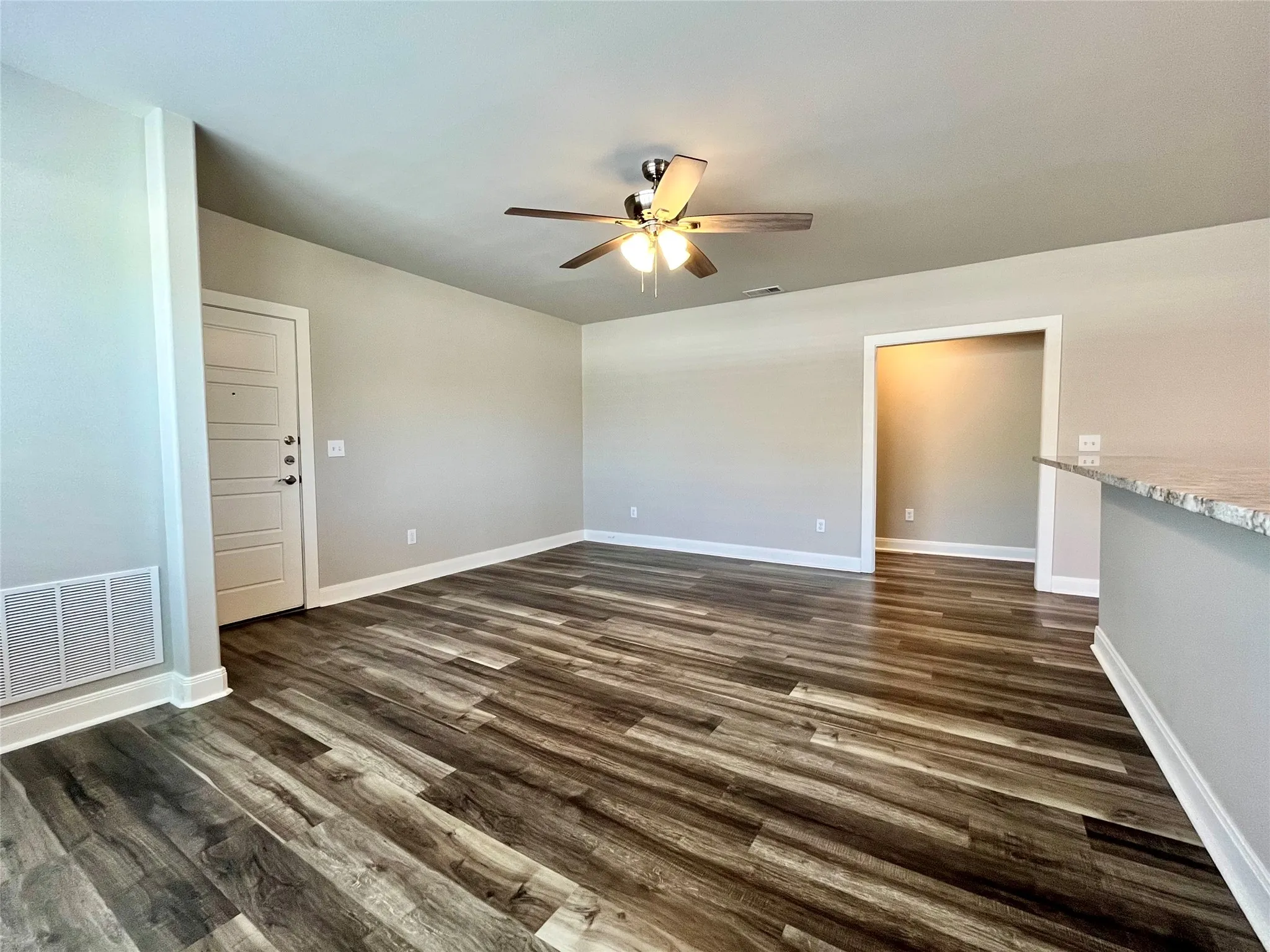 Spacious living area featuring beautiful, contemporary wood-look flooring.