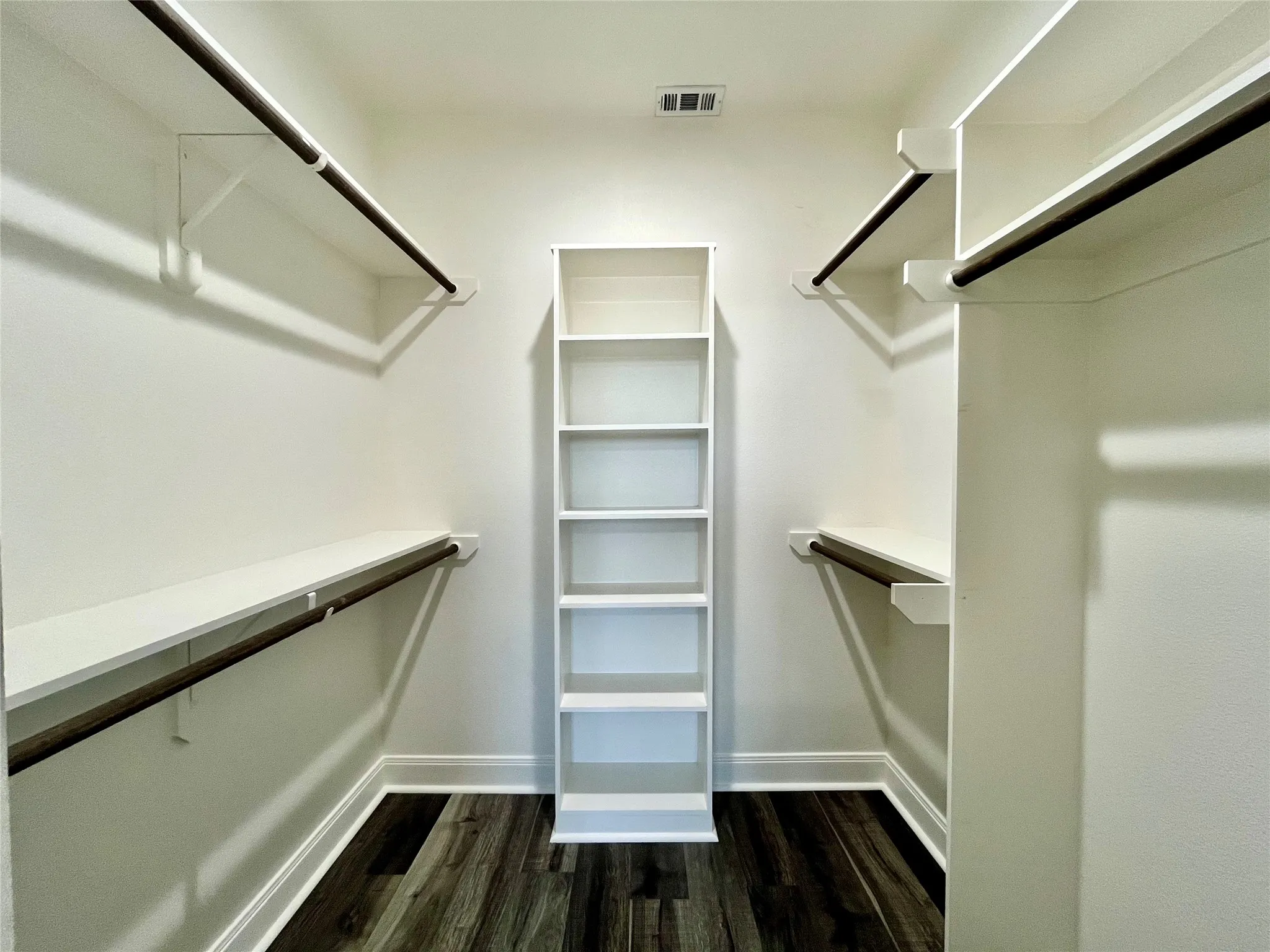 Impressive walk-in closet featuring extensive built-in shelving and organizers.