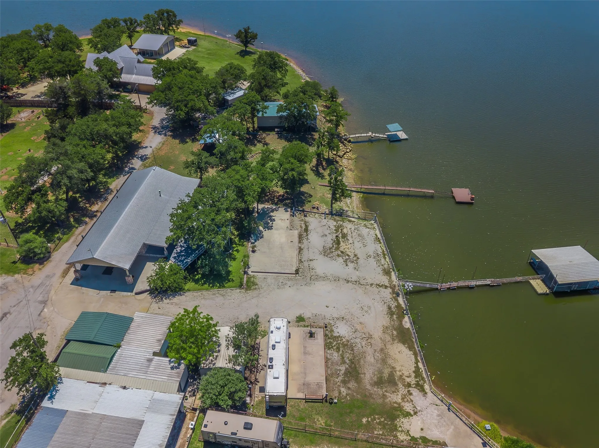 Extensive waterfront property featuring multiple structures, private docks, mature trees, and a substantial boat house
