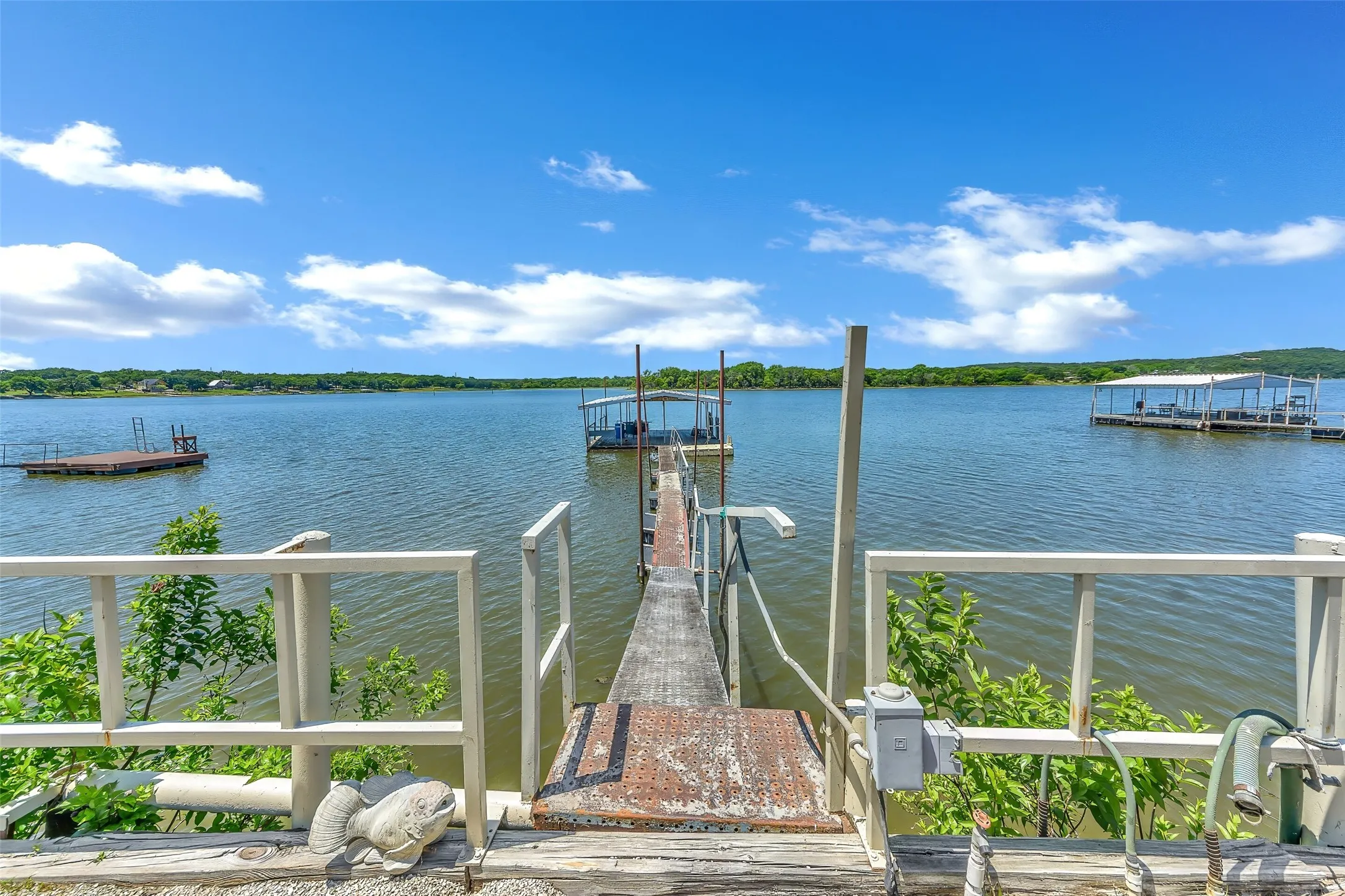 Lakefront property featuring a private boat dock with a covered slip, a separate floating swim platform, and expansive water frontage
