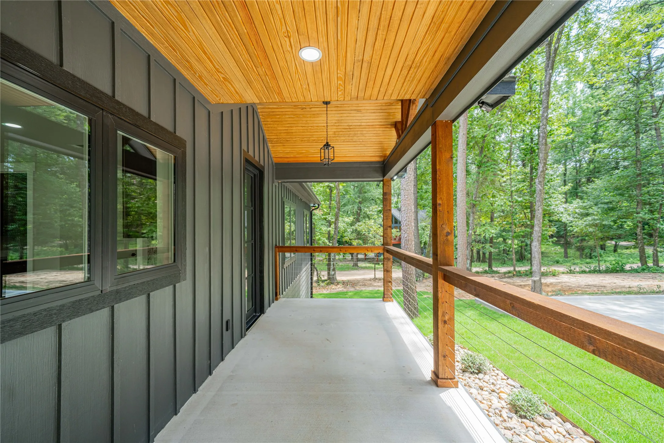 Expansive covered porch featuring a wood-plank ceiling with recessed lighting and a hanging lantern fixture