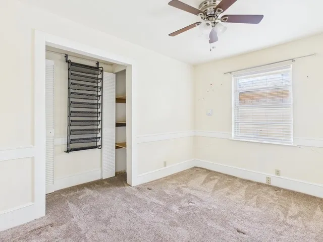 Unfurnished bedroom with carpet flooring, baseboards, and a ceiling fan