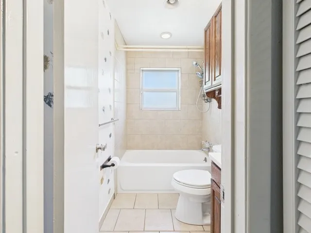 Bathroom with tile patterned floors, vanity, toilet, and shower / washtub combination