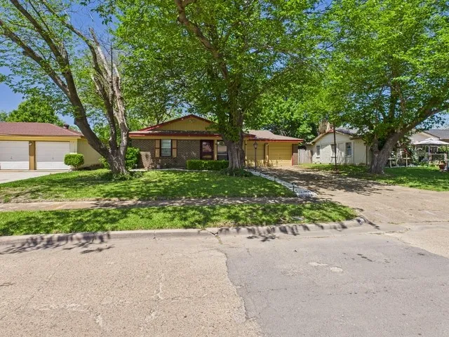Ranch-style home featuring driveway, a front yard, and a garage