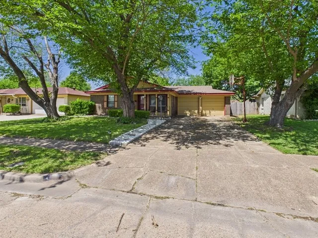 Ranch-style house with an attached garage, driveway, and a front yard