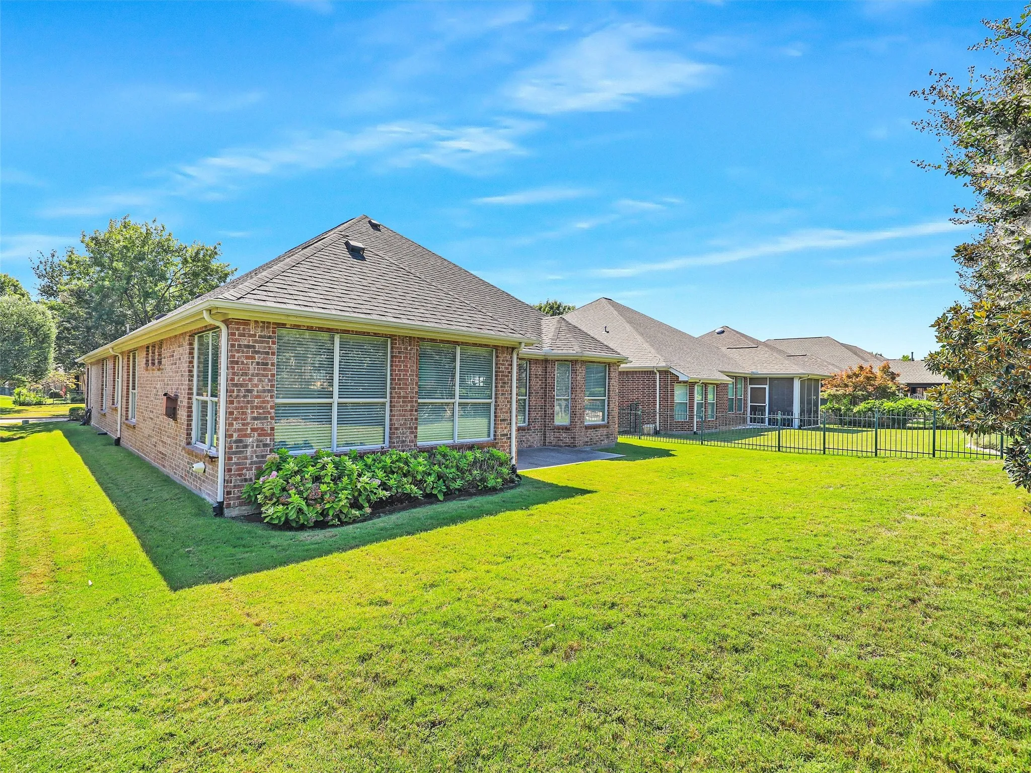Back of property with brick siding and a shingled roof