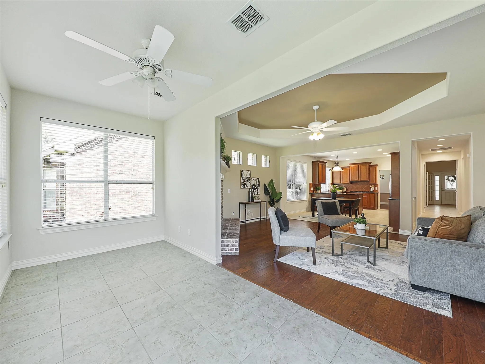 Living room with a tray ceiling, plenty of natural light, and light tile patterned flooring