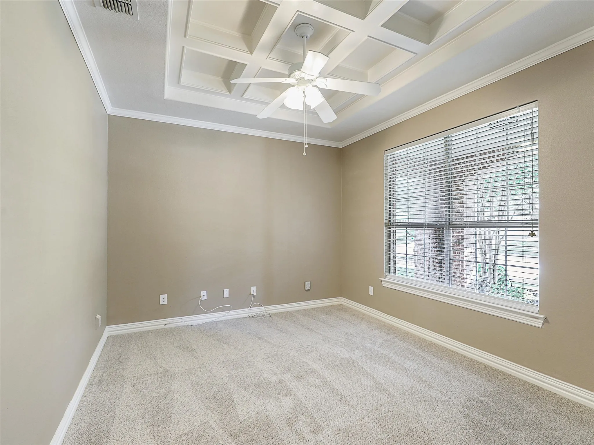 Study with coffered ceiling, beam ceiling, light carpet, ornamental molding, and ceiling fan