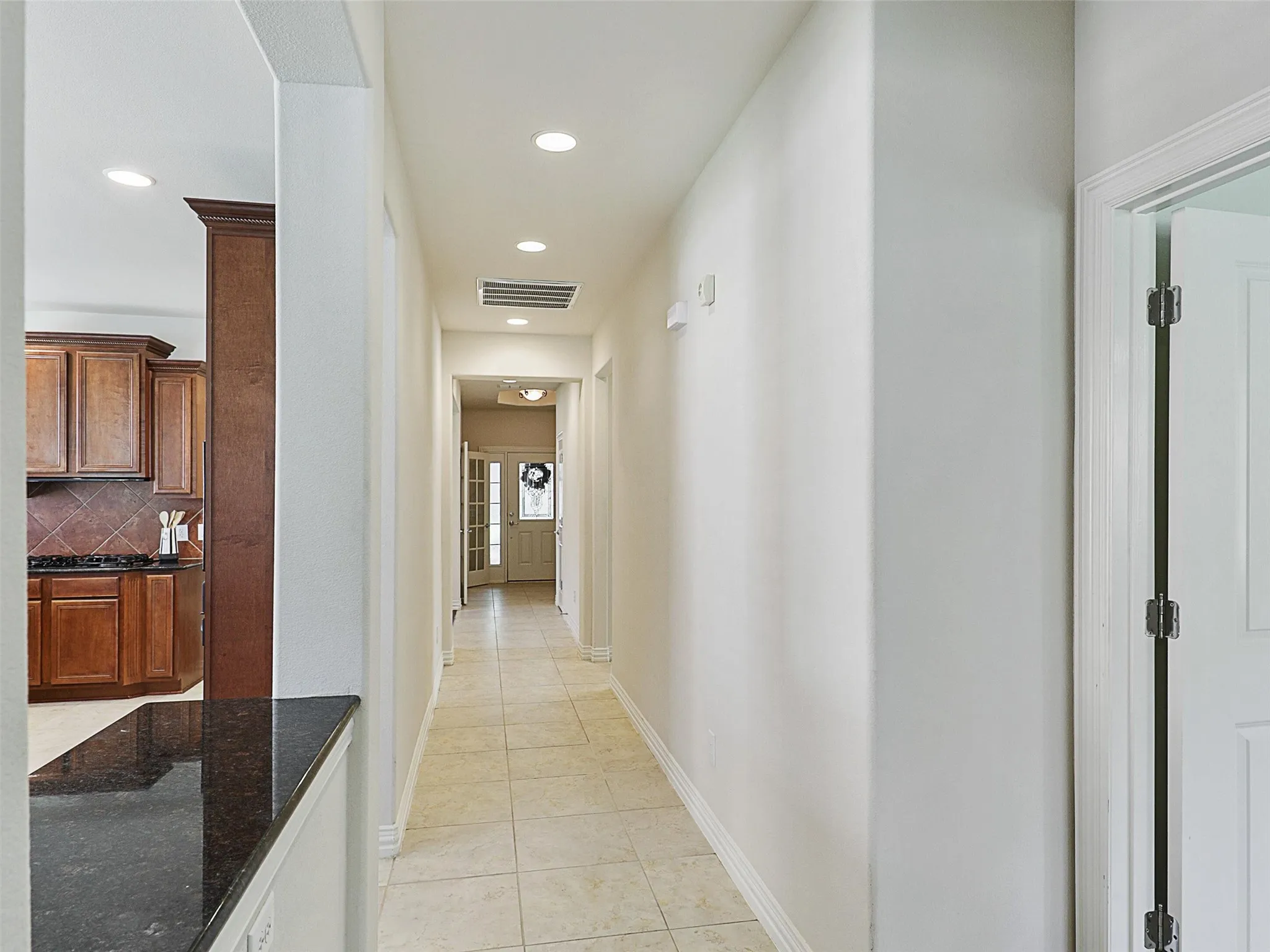 Hallway with light tile patterned flooring and recessed lighting