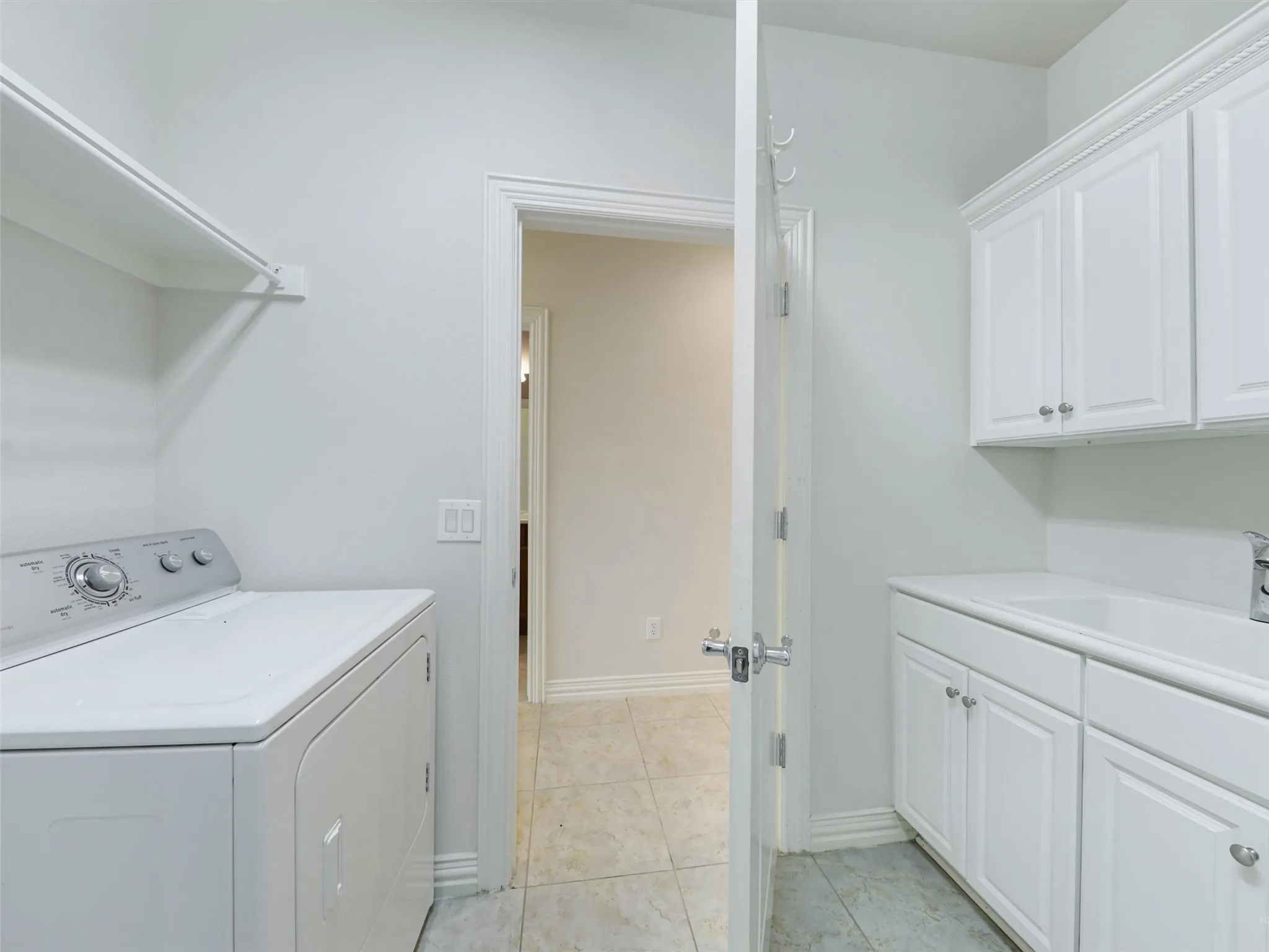 Washroom with washer / clothes dryer and light tile patterned floors