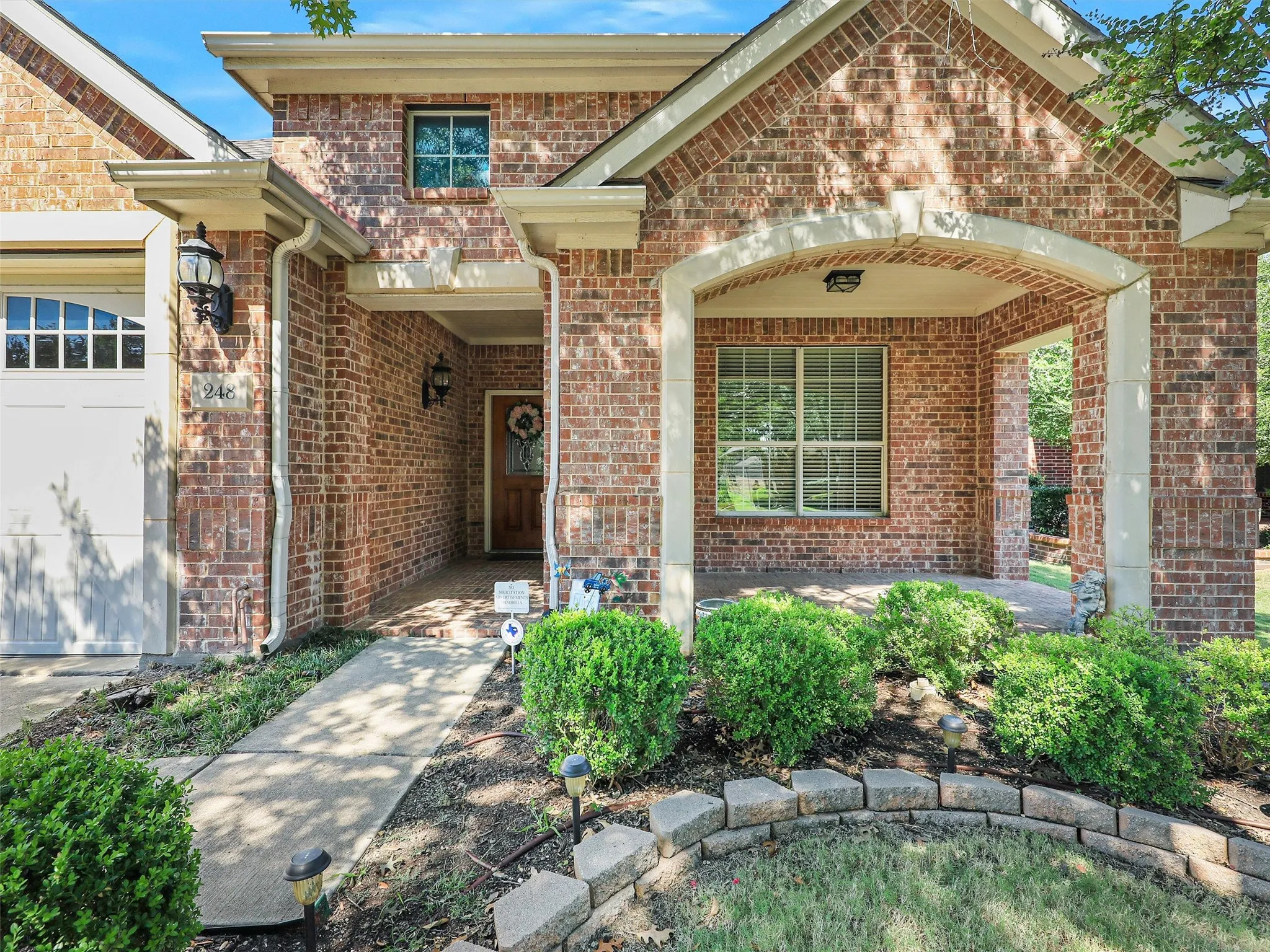 Doorway to property with brick siding and a garage