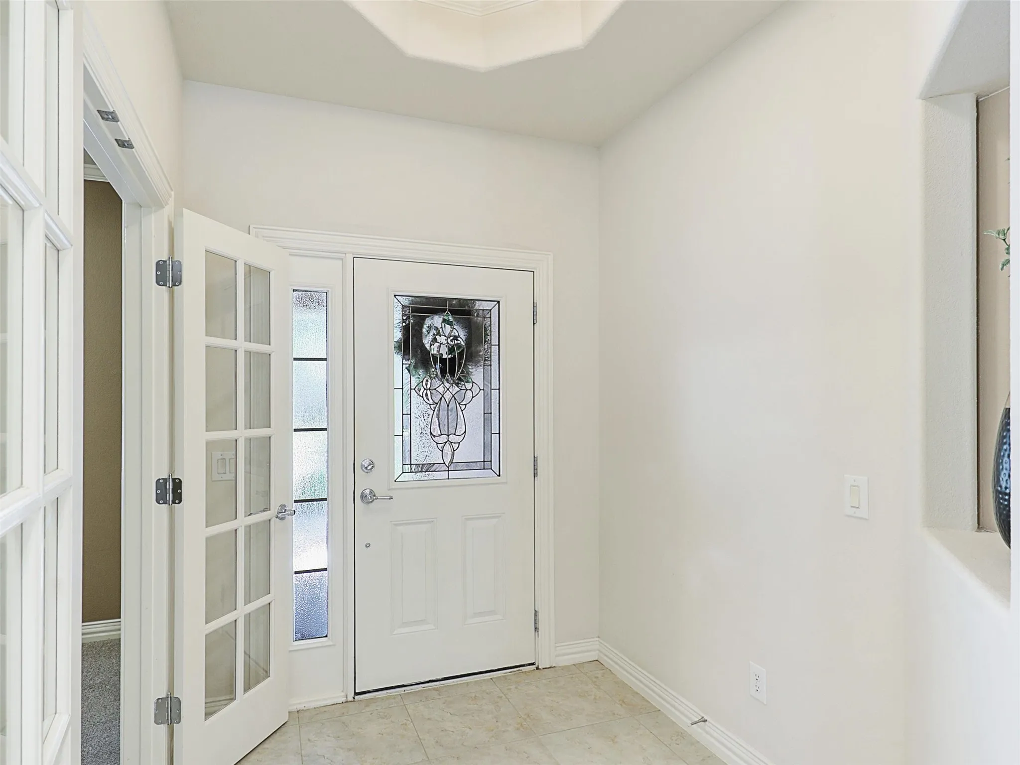 Doorway with Art niche, tile patterned flooring and french doors to the study