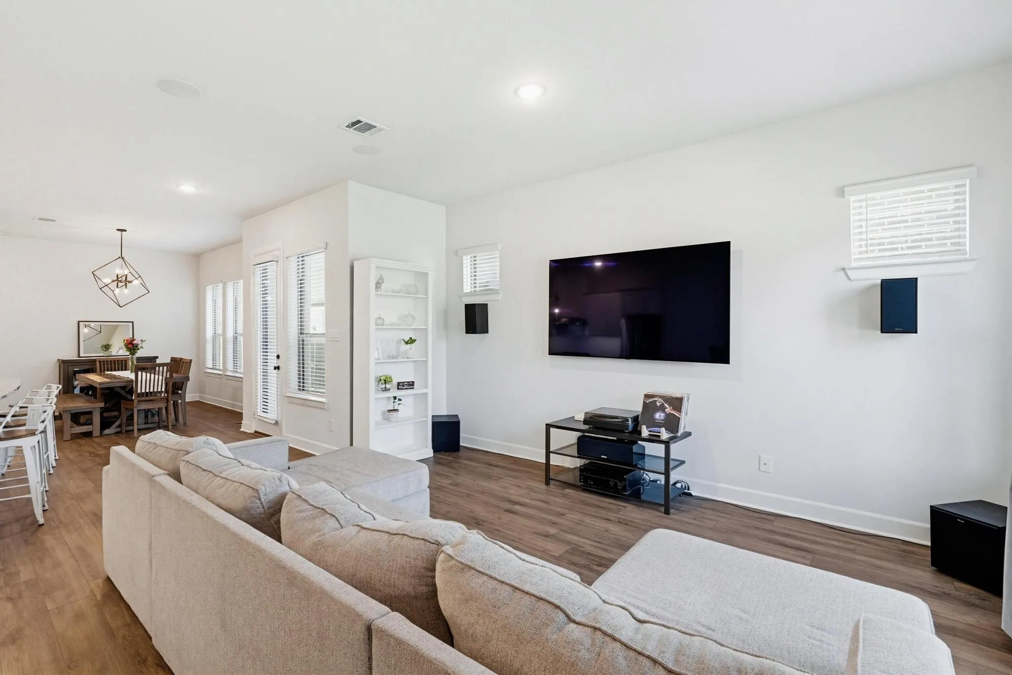 Open-concept living area featuring wood-finish flooring and recessed lighting