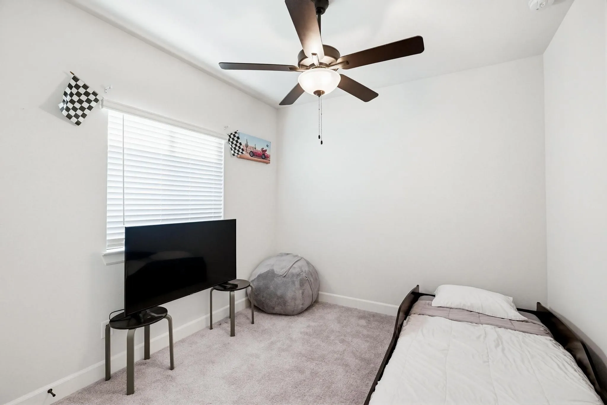 Room featuring light-toned walls, a ceiling fan with integrated lighting, a window with horizontal blinds, and carpeting