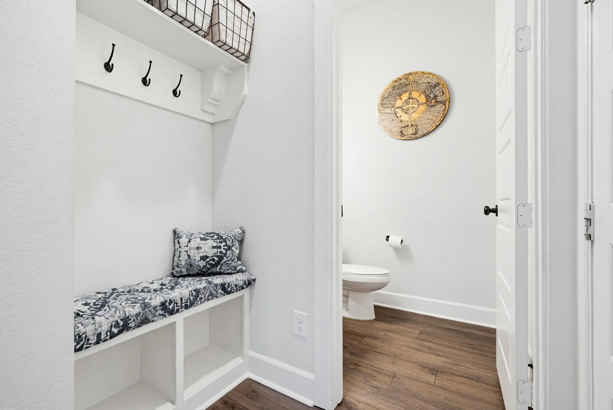 Built-in mudroom bench with cubby storage and black coat hooks