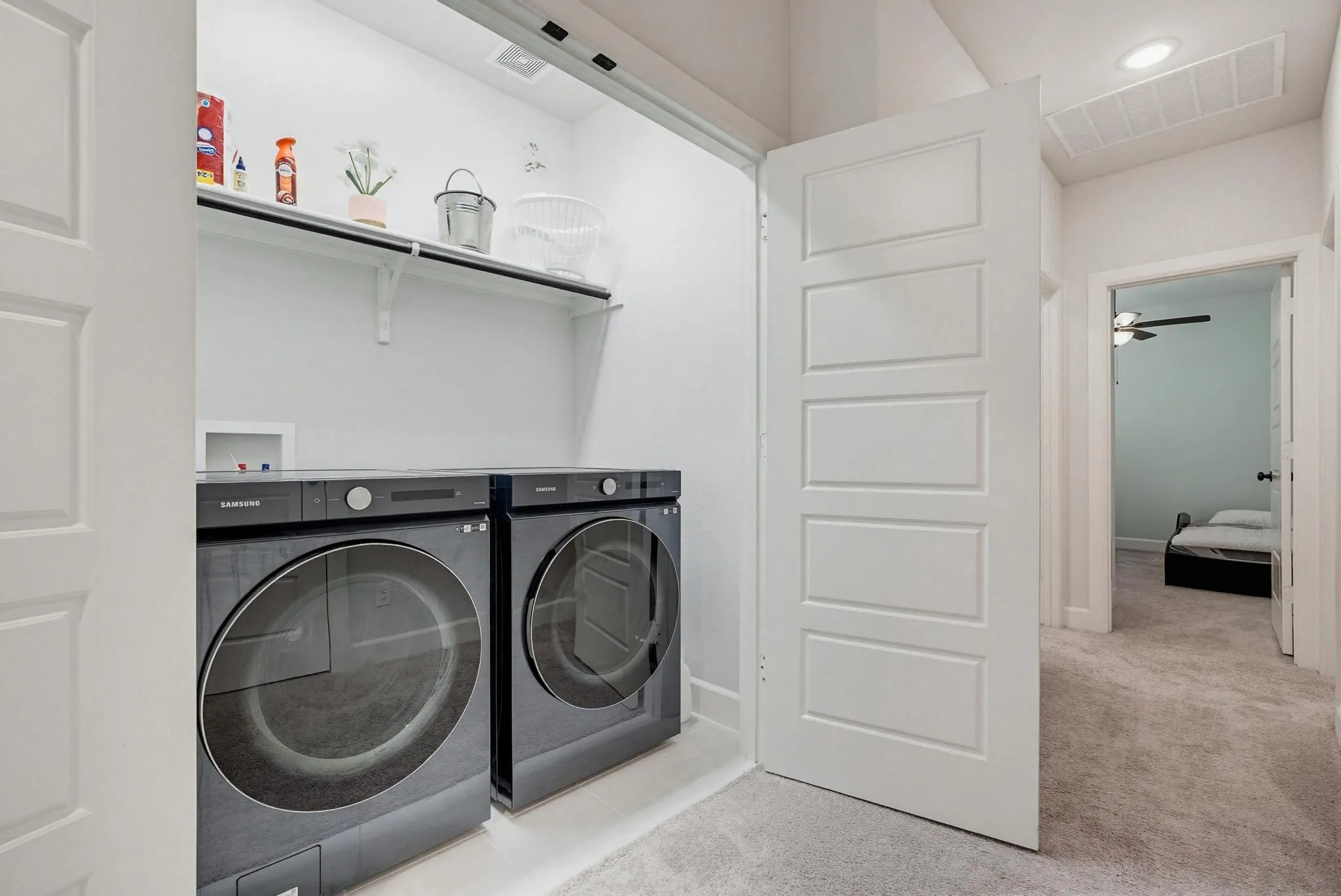 Dedicated laundry closet featuring a built-in shelf, white walls, and light-colored flooring