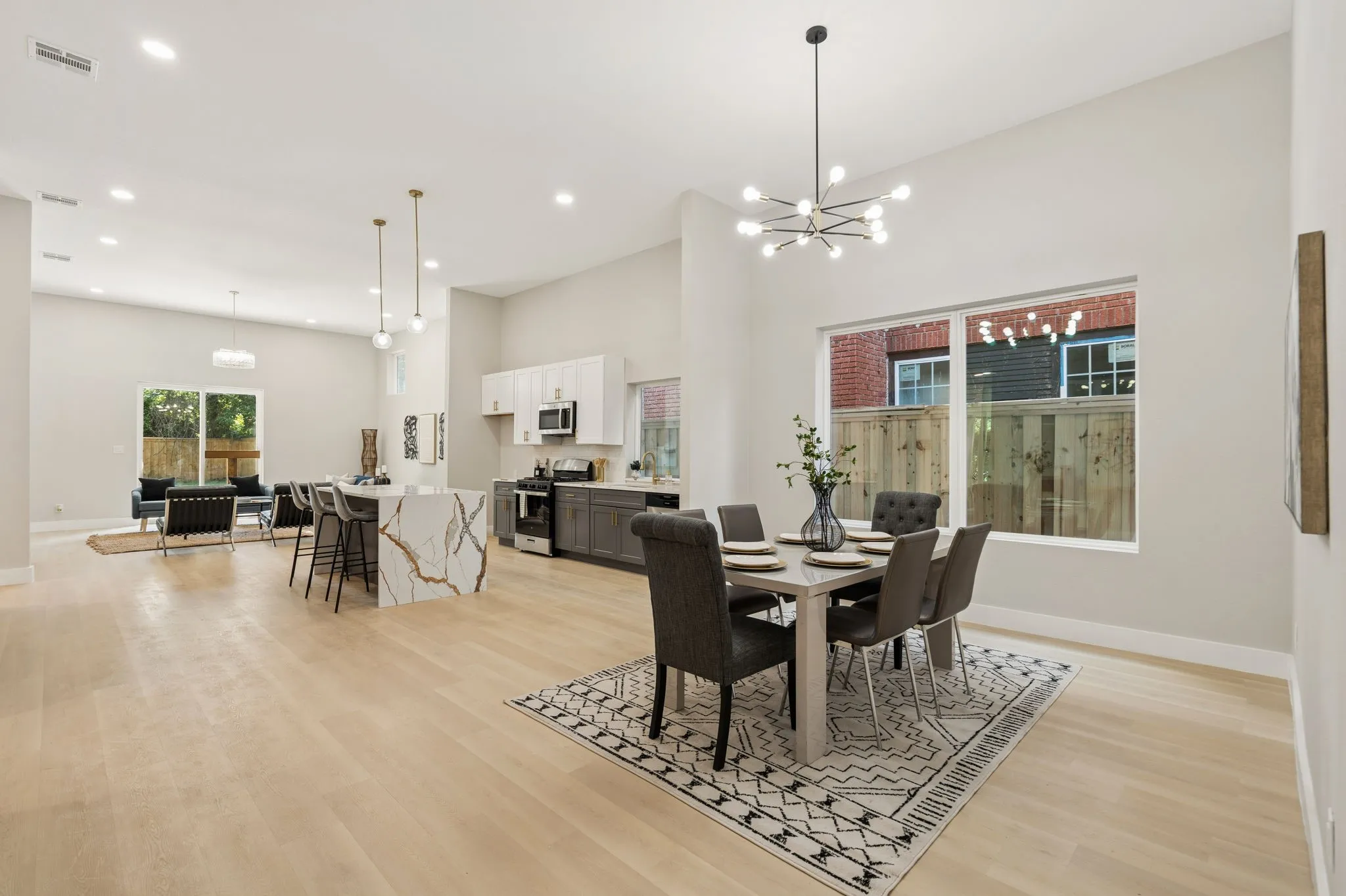 Expansive open-concept space featuring light wood-finish flooring, vaulted ceilings, and recessed lighting