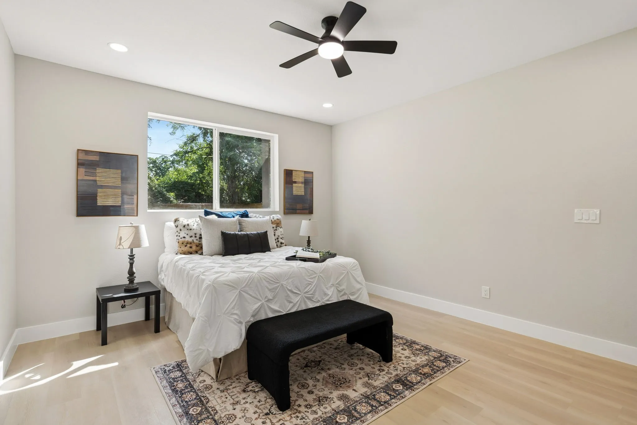 Spacious room featuring wood-finish flooring, a large window, a ceiling fan, and recessed lighting