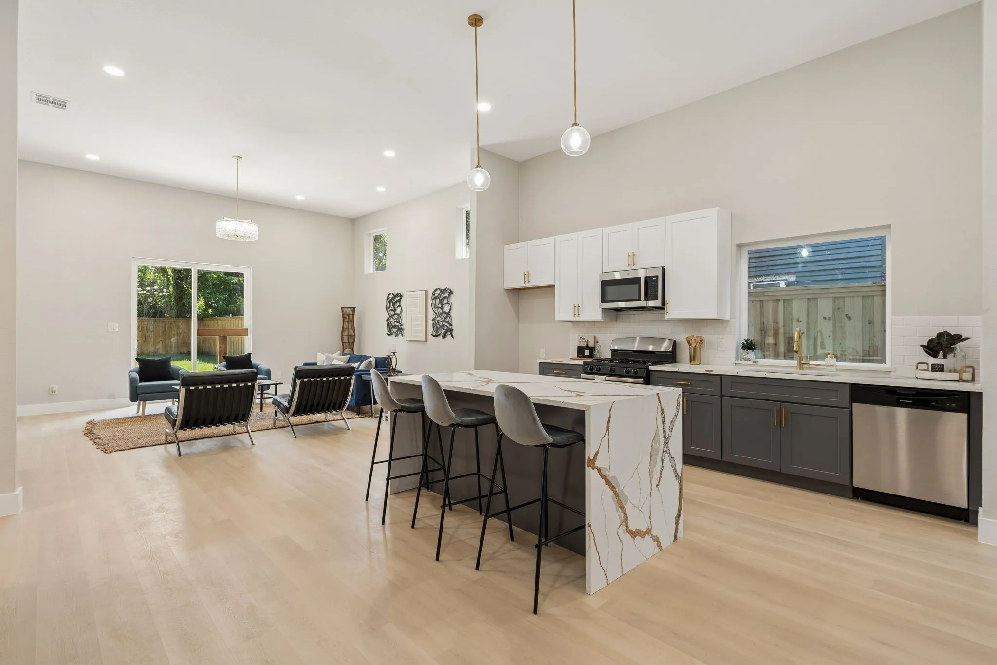 Open-concept living area featuring light wood-finish flooring and high ceilings