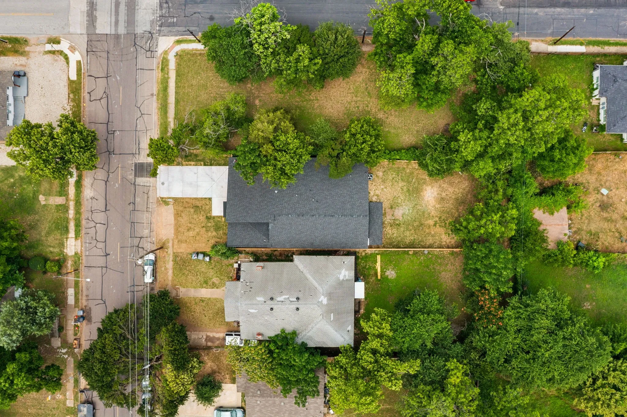 Aerial perspective showcasing two properties with distinct rooflines and surrounding green spaces