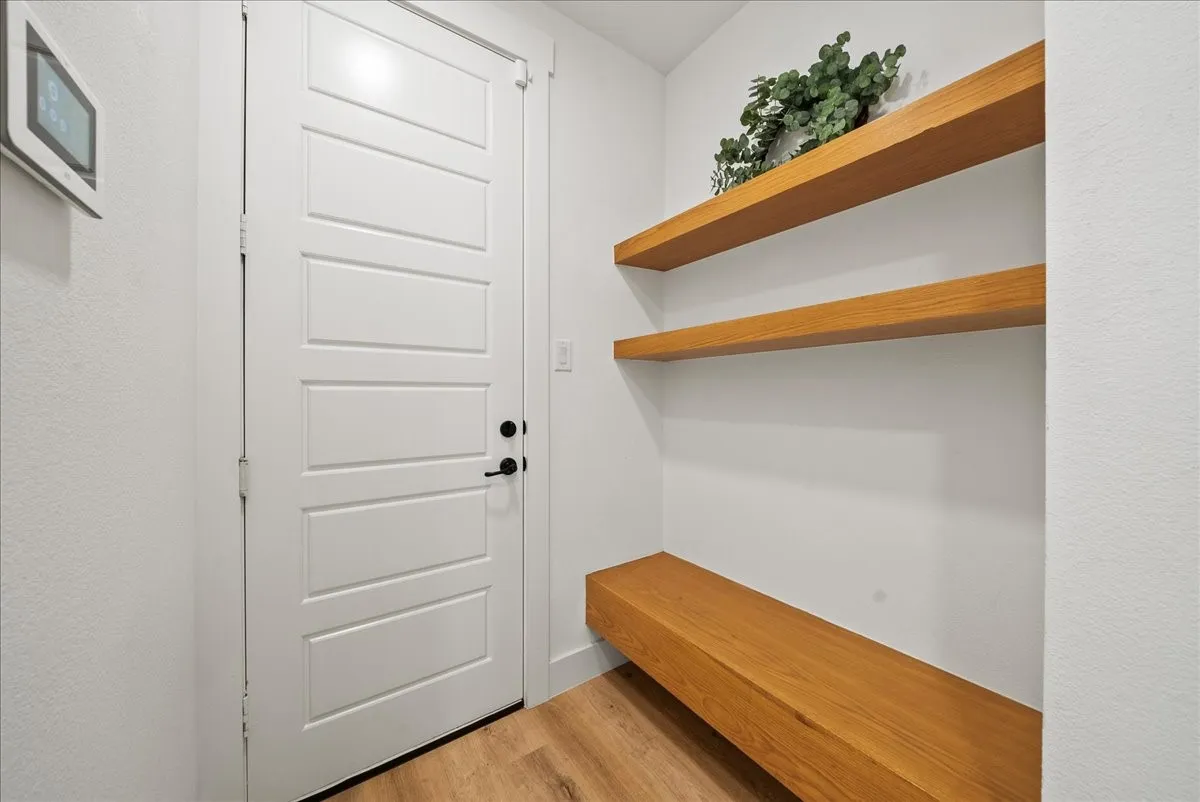 Mudroom located behind Eat-in Kitchen with Built-in Seating and Shelves leading to Garage