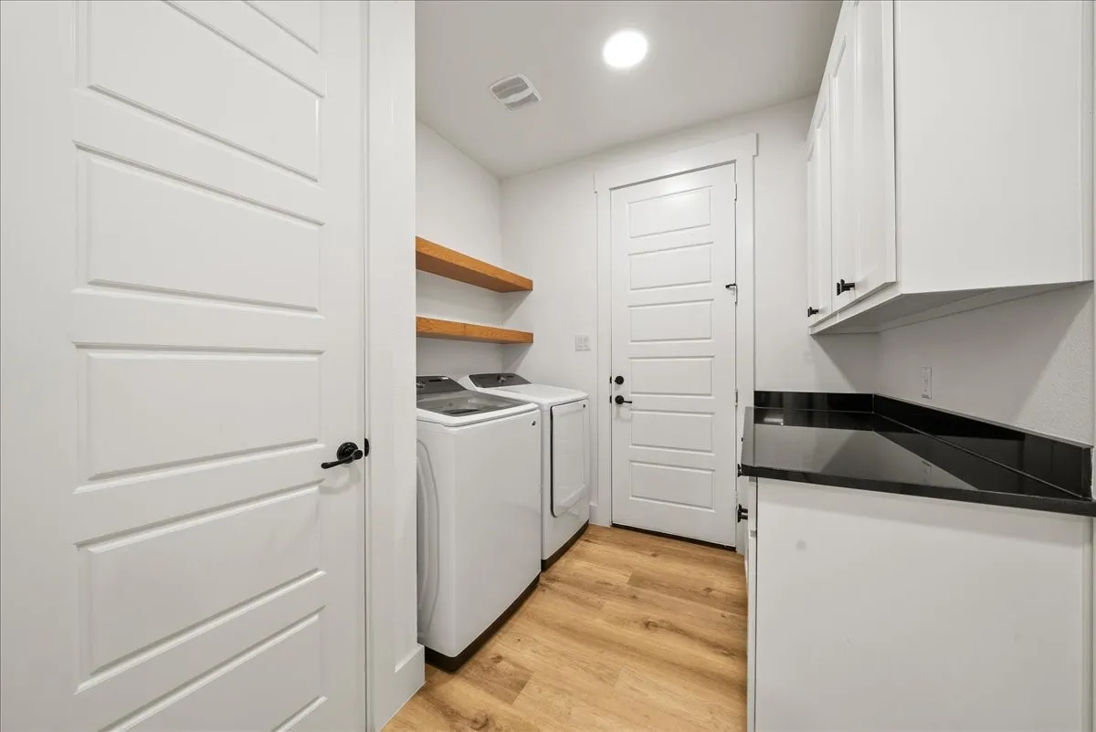 Located behind Eat-in Kitchen is Full Size Washer & Dryer Area connected to Primary Bedroom Custom Walk-in Closet, and Built-in Cabinetry