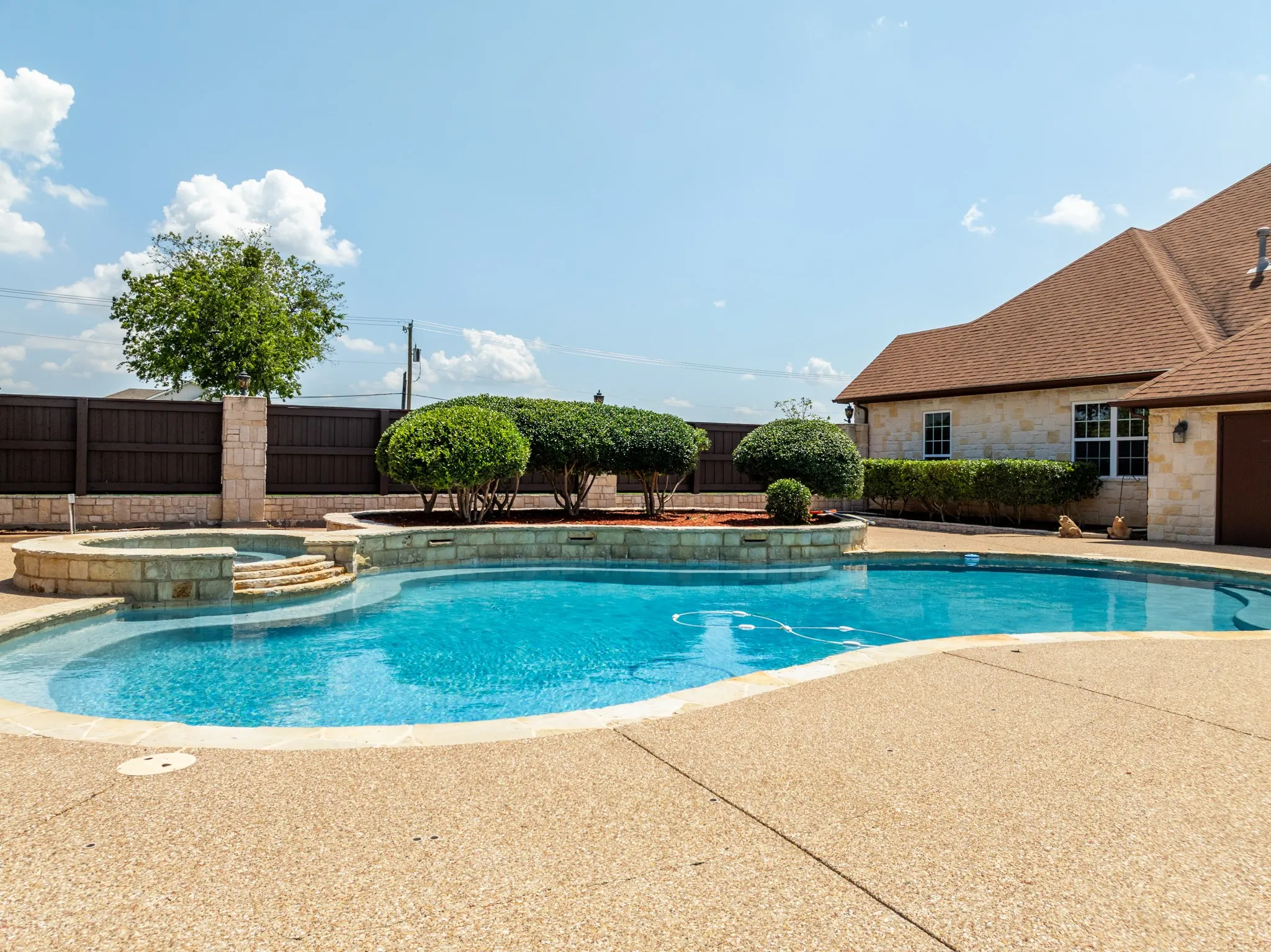 Salt water pool and hot tub surrounded by meticulous landscaping