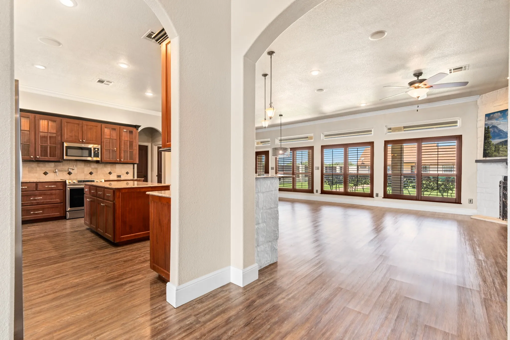 Kitchen featuring glass insert cabinets, large serving island, custom fridges, pot filler, wine coolers, and pot filler.